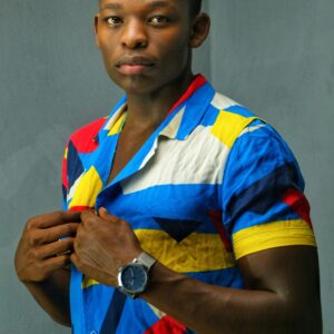 Portrait of a man in a vibrant shirt posing confidently indoors.